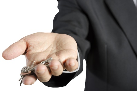 business man with house key in hand- real estate concept, isolated on white backgroundの写真素材