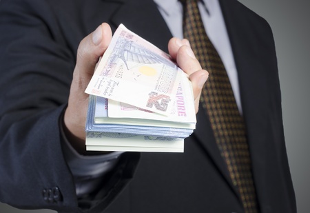 businessman showing packs of international bank noteの写真素材