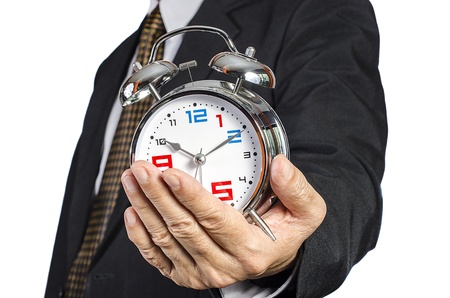 Businessman hold alarm clock in hand, isolated white backgroundの写真素材