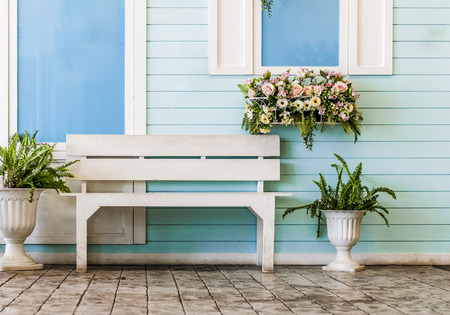 White chair and artificial flowers on retro houseの写真素材