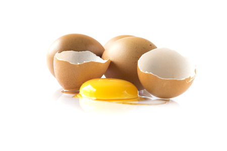 Raw egg yolk with the cracked open egg shell , Isolated on white backgroundの写真素材