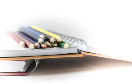 Spiral notebook and color pencils on white backgroundの写真素材