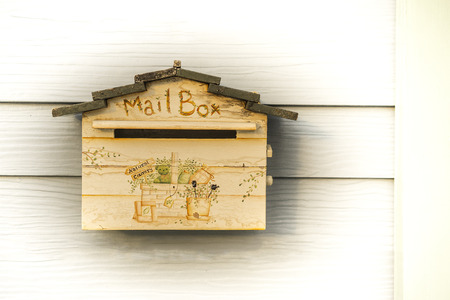 Wooden mailbox in front of wooden houseの写真素材