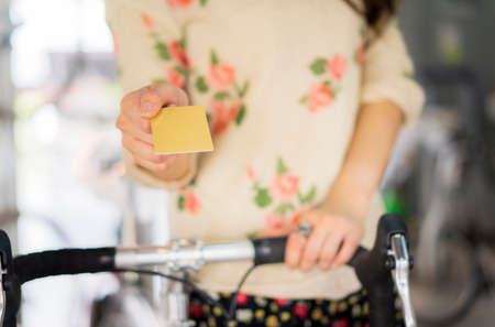 Woman with bicycle and credit cardの写真素材