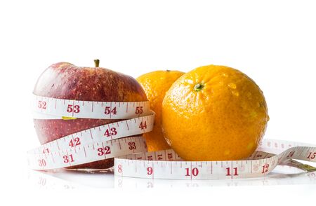 Red apple and orange with measure tape , Isolated on white backgroundの写真素材