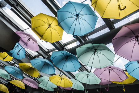 Colorful umbrella decoration under glass roofの写真素材