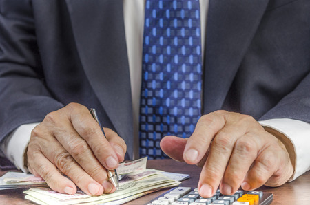 Business people calculating profit - closeup shot of hands using calculator : Concept for Business and Moneyの写真素材