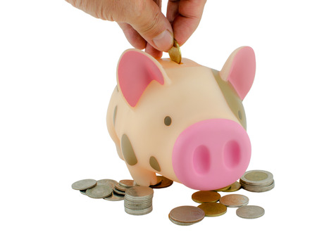 Hand putting coin into piggy bank : Isolated on white backgroundの写真素材