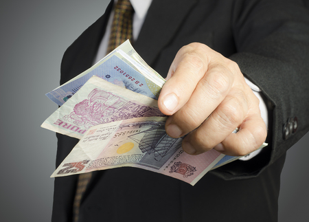 businessman showing packs of international bank noteの写真素材