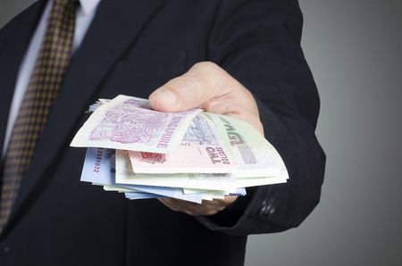 businessman showing packs of international bank noteの写真素材
