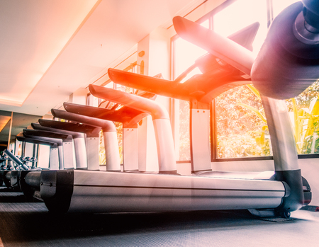 Empty raw of treadmill in fitness room at the morningの写真素材