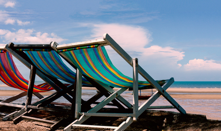 Old wooden beach chair on the beach in the morning for relaxationの写真素材