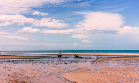 Scenic view of calm beach and fishing boat at the morningの写真素材