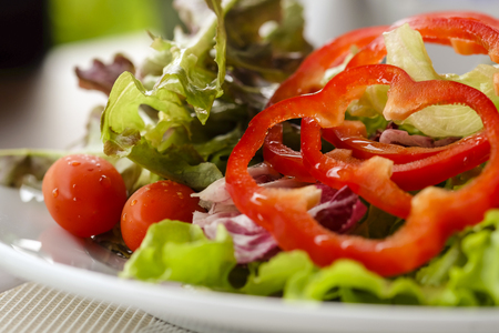 Healthy salad served with tomato and sweet peppersの写真素材