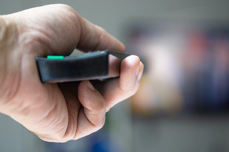 Hand using remote control at home entertainment , Focus on hand : Concept for technology and...