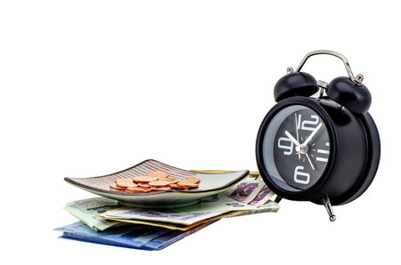 Alarm clock and banknote under coins in saucer , Isolated on white background