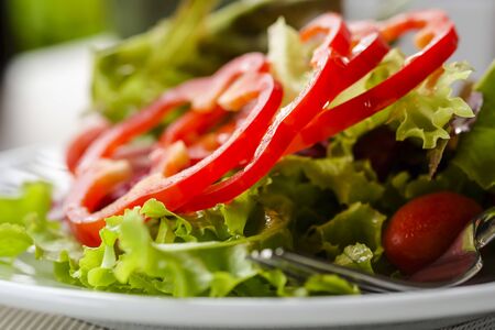 Healthy salad served with tomato and sweet peppersの写真素材