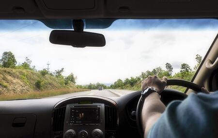 Man driving car along highwayの写真素材