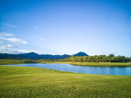Beautiful landscape view of lawn and mountain under clear sky in the morningの写真素材