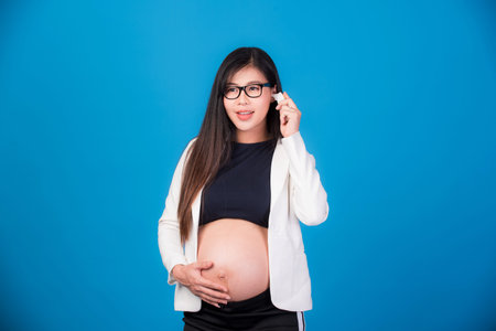 Beautiful pregnant woman portrait Asian woman isolated on blue background. Facial expressions,...
