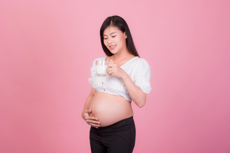 Portrait of Beautiful pregnant woman asia young woman,isolated on yellew background. Human face expressions, emotions feelings, body language,beauty and fashion concept.の写真素材