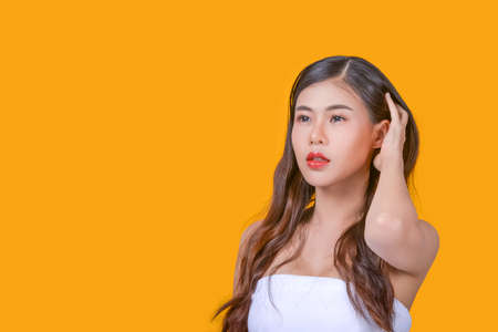 Beauty and healthcare. Portrait of young and beautiful asian woman on yellow backgroundの写真素材
