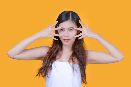 Beauty and healthcare. Portrait of young and beautiful asian woman on yellow backgroundの写真素材