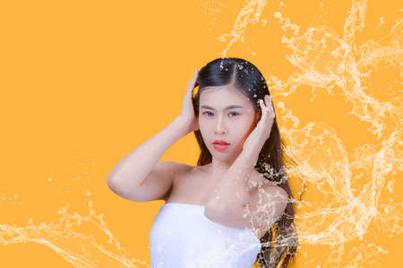 Beauty and healthcare. Portrait of young and beautiful asian woman on yellow backgroundの写真素材