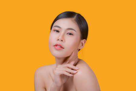 Beauty and healthcare. Portrait of young and beautiful asian woman on yellow backgroundの写真素材
