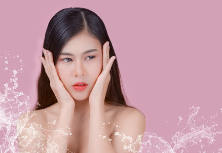 Portrait of a woman using water to wash her face, Beauty Spa Woman with perfect skin Portrait. Asian beautiful woman skin makeup young model,on pink studioの写真素材
