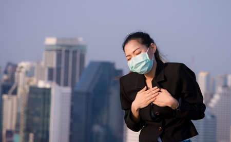 Portrait of an Asian woman wearing a black oil mask, anti-virus, or anti-Covid-19. Feeling stressedの写真素材