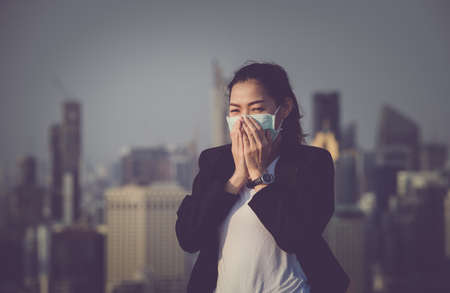Portrait of an Asian woman wearing a black oil mask, anti-virus, or anti-Covid-19. Feeling stressedの写真素材