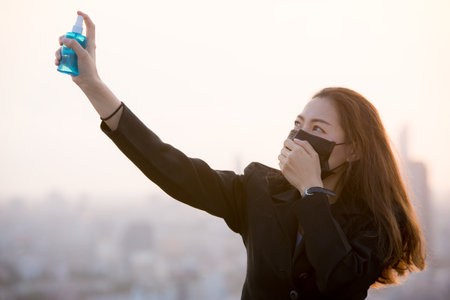 Portrait of an Asian woman wearing a black oil mask, anti-virus, or anti-Covid-19. Feeling stressedの写真素材