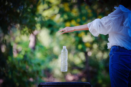 Asian Young women putting empty plastic bottle in recycling bin.Environmental conservation.の写真素材