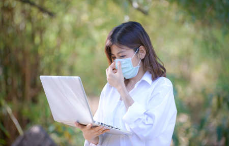 Portrait of an Asian woman wearing a black oil mask, anti-virus, or anti-Covid-19. Feeling stressedの写真素材