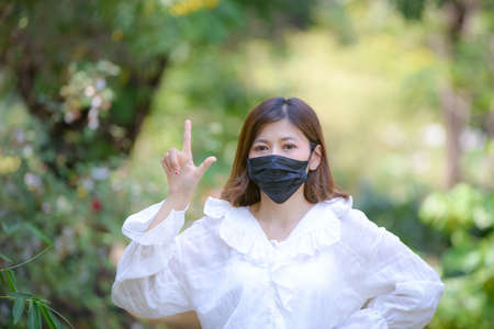 Portrait of an Asian woman wearing a black oil mask, anti-virus, or anti-Covid-19. Feeling stressedの写真素材