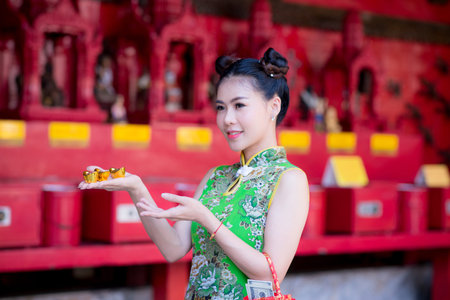 Action portrait beautiful Asian girl wearing Cheongsam green dress. the celebration of something in...
