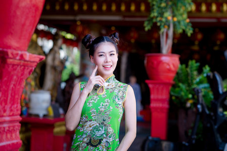 Action portrait beautiful Asian girl wearing Cheongsam green dress. the celebration of something in a joyful and exuberant way. Festivities and Celebration conceptの写真素材