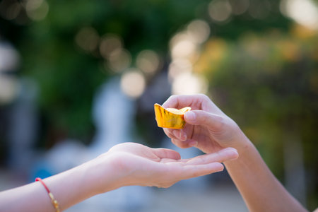 Close up hand sending and receiving red envelope Symbols of the Chinese New Year on golden bokeh background. gifts, festivals and celebration conceptの写真素材