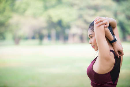 Asian Young female athlete jogging in forest. Jogger doing morning physical training.の写真素材
