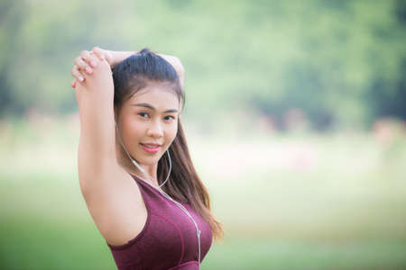 Asian Young female athlete jogging in forest. Jogger doing morning physical training.の写真素材