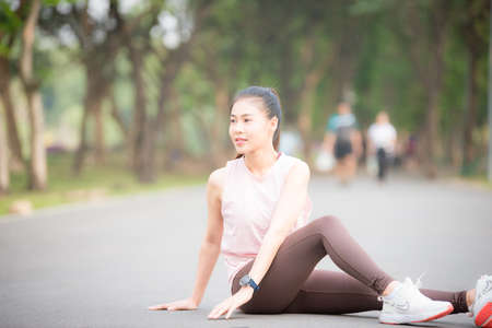 Asian Young female athlete jogging in forest. Jogger doing morning physical training.の写真素材