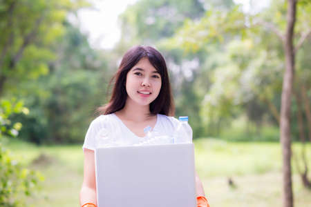 Woman hand picking up garbage plastic for cleaning at parkの写真素材