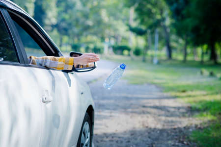 Woman hand picking up garbage plastic for cleaning at parkの写真素材