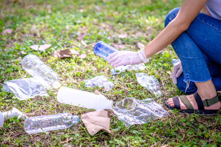 Woman hand picking up garbage plastic for cleaning at parkの写真素材