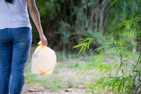 Woman hand picking up garbage plastic for cleaning at parkの写真素材