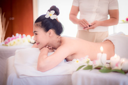 Body care. Spa body massage Asian woman hands treatment. Woman having massage in the spa salonの写真素材