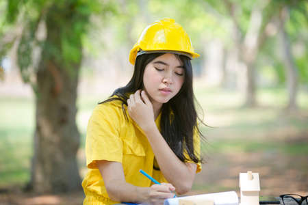 Beautiful Asia Young Female engineer is sitting drawing to add to the relaxing garden.の写真素材