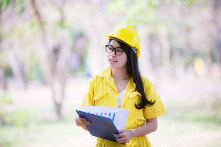 Beautiful Asia Young Female engineer is sitting drawing to add to the relaxing garden.の写真素材