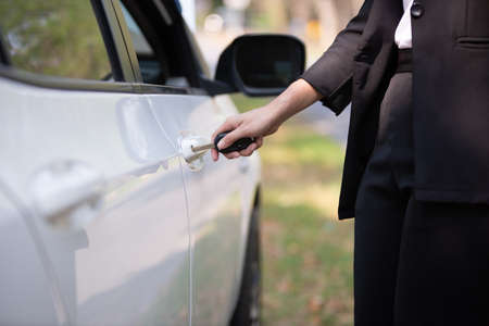 à¹Hand of a businesswoman with a key opening the car doorの写真素材